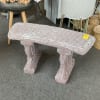 A concrete bench with cascading leaf details. The bench and legs are