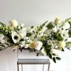 Flower arrangement with premium white blooms and dark green foliage, arranged in