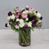 The arrangement features spray rose, ranunculus, and tulips for a sweet look.
