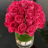 25 Kiko Roses mounded in a clear glass vase wrapped in aspidistra