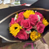 dozen pink roses with greenery, and sunflowers wrappen in black tissue paper