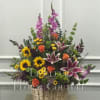 A beautiful floral arrangement of various flowers and colors in a wicker