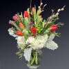 Brimming with exquisite tulips and Hydrangea, this bouquet in a classic glass