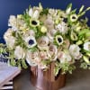 Vased arrangement in pastel and white colors with roses, spray roses, anemones