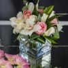 Elegant combination of white and pink roses, greenery and orchids in clear