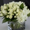 Classic mix of white roses, spray roses and hydrangeas. Arranged into square