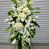 This is an elegant funeral standing spray composed of white flowers, symbolizing