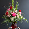 A lush airy arrangement filled with Roses, Lilies, Alstroemeria, Bells of Ireland