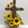 Wooden cross surrounded with permanent sunflowers and grasses in ceramic bowl