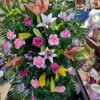Colorful standing spray with multiple different colors of lilies, fuchsia roses, pink