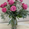 One dozen Lavender rose artfully arranged in a vase with accent flower