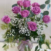 One dozen Lavender rose artfully arranged in a vase with accent flower