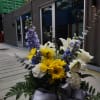 An arrangement of yellow roses, delphinium, white lilies, monte casino, greenery and