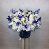 This elegant arrangement features a stunning combination of crisp white roses, delicate