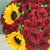 This striking arrangement showcases bold red roses paired with vibrant yellow sunflowers.