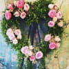 Smilax greenery with roses, spray roses, and garden roses on an easel