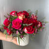 An aesthetic arrangement with hot pink roses , spray red roses, wax