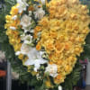 A full heart with open yellow roses and spray roses ,like broken