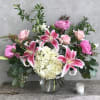 An array of pink blooms, such as peonies, roses, and lilies, arranged