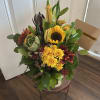 This beautiful arrangement is a lovely mix of alstroemerias, sunflowers, poms, leucadedron