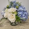 A spring vase arrangement of soft blue and white blossoms, 
