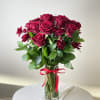 One dozen long stemmed red roses with greenery. Photo depicts the deluxe
