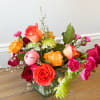 Arrangement in a low vase full of colorful blooms