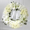 Honor and remember with a serene round wreath featuring white roses, white