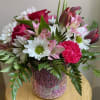 A colorful keepsake vase filled with shades of pink and pops of