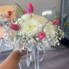 The product contains roses, tulips and is tied with white ribbon 