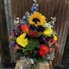 A variety of bright colored flowers arranged in a vase. 