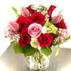Red and pink bouquet with artificial strawberries in a clear vase