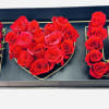 A beautifully arranged floral design using fresh red roses, forming the letters