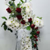 white daisy mum, red roses across the middle with greenery on easel