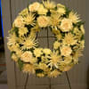 18&quot; Wreath adorned with a lush greens and yellow floral mix (spider