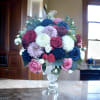 An elegant arrangement of fresh flowers: roses, delicate carnations, and lush dahlias.