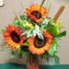 A beautiful mixed arrangement with sunflowers and other seasonal blooms.