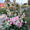 A rustic cross adorned with stargazer lilies, hydrangea and sweetly scented stock.
