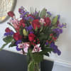 Moix vase filled with oriental lilies , Carnation roses and purple flowers