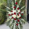 Red and White standing spray. Flower type may vary depending on local