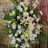 An all white sympathy standing spray with premium flowers.
