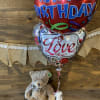 Soft and sweet teddy bear with birthday and I love you balloons.