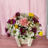 This sweet arrangement is designed in a whitewashed wooden container and includes