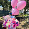 Round box with assorted flowers in seasonal colors, teddy bear and balloons