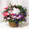 A basket of mixed blooms topped off with a handle of fragrant