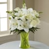 Colored vase with all white flowers, snapdrangons, lilies &amp; roses.