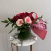 A short and modern styled arrangement of red and pink roses. The
