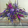 Another beautiful style of casket floral arrangement, featuring varying hues of purple.