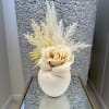  A delicate white vase featuring a soft blend of feathers and