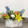 Colorful assortment of fresh flowers arranged in an envelope shaped keepsake vase.